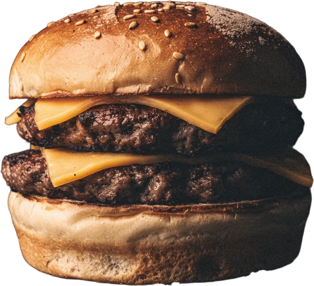 Ein Burger auf dem selbst geschmiedeten Rost, umgeben von Buchenholzkohle